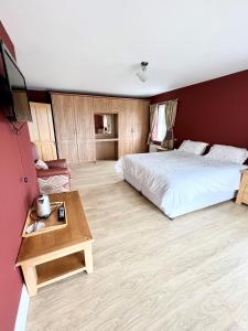 um quarto com uma cama grande e uma mesa em Bridie's Place em Ballycastle