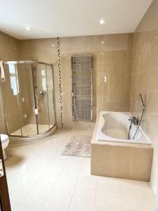 a large bathroom with a tub and a shower at Bridie's Place in Ballycastle