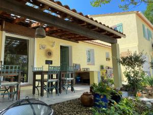 une terrasse avec une table et des chaises dans une maison dans l'établissement L'Eveil en Provence, à Entrecasteaux