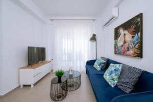 sala de estar con sofá azul y TV en Danai & Palm Residential Complexes, en Ofrinion