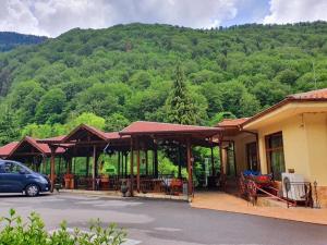 uma casa com um carro estacionado em frente em Family Hotel Gorski Kut em Rilski Manastir