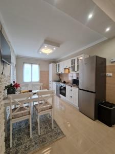 cocina con mesa y nevera de acero inoxidable en Belvárosi BástyaVár Apartman, en Gyula