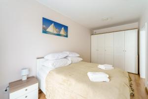 um quarto com uma cama grande e toalhas em Apartamenty SUNSET RESORT SurfingBird Grzybowo em Grzybowo