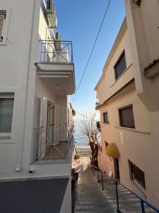 a view of the ocean from between two buildings at Ammoudeli Apartments in Plomari