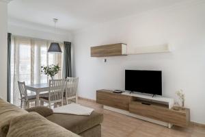 Una sala de estar con un sofá, un televisor y una mesa. en Ganivet Home, en Arrecife