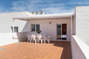 Un patio con una mesa y sillas en una casa. en Ganivet Home, en Arrecife