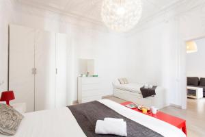 een witte slaapkamer met een bed en een kroonluchter bij AB Passeig de Gràcia Pelai in Barcelona