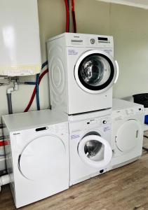 two washing machines and a washer and dryer in a room at Neuwertiges Apartment mit schnellem WLAN, Glasfaser, Kostenlose Privatparkplatz auch für Transporter geeignet R8 in Freiberg am Neckar