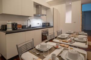 a kitchen with four tables and chairs in a room at Costa Suites in Palermo