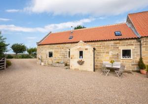 a stone building with a picnic table in front of it at Apple Barn in Fylingdales