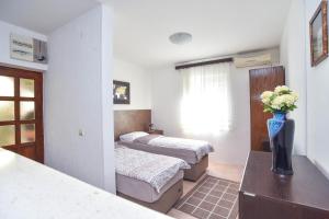 a bedroom with two beds and a table with flowers at Branka Apartments in Tivat