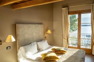 1 dormitorio con 1 cama y ventana grande en Hotel Villa Maria Au Lac - Estella Hotels Italia, en Toscolano Maderno