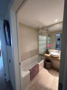 La salle de bains est pourvue d'une baignoire, d'un lavabo et d'une baignoire. dans l'établissement Villanueva Golf- Cozy 2 Bedrooms -Puerto Real, Cádiz, à Puerto Real