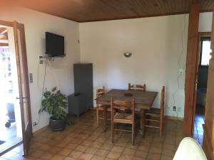 a dining room with a table and chairs and a tv at Appartement plain-pied vacances in Cazaubon