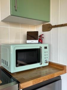 a microwave sitting on top of a counter in a kitchen at Dune Shepherds Hut in Penally