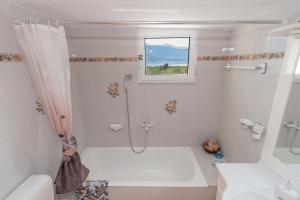 een witte badkamer met een douche en een raam bij SEA & OLIVES HOUSE in Lixouri