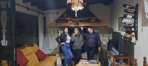 un grupo de tres personas de pie en una sala de estar en Jardin Secreto Russell Maipu en Mendoza