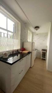 uma cozinha com um frigorífico branco e uma janela em Landelijke huis in de Betuwe em Tricht