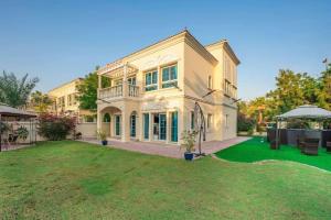 a large house with a green lawn in front of it at Key View - District 8A Villa JVT in Dubai