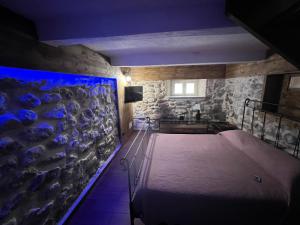 a bedroom with a bed and a stone wall at L’antico casale in Reggio Calabria