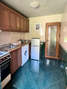een keuken met een witte koelkast en een vaatwasser bij Guesthouse Parnavaz Mepe in Batoemi