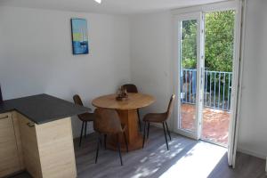 uma cozinha com mesa e cadeiras e uma varanda em La petite Rascasse, Appartement avec Terrasse ensoleillée em Rayol-Canadel-sur-Mer