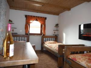 - une chambre avec 2 lits et une bouteille de vin sur une table dans l'établissement V ZAJEČSKEJ VĚŽI, à Zaječí