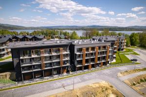 an aerial view of a building with a lake in the background at Apartament Mglisty Poranek - Laguna Beskidów - Dream Apart in Zarzecze
