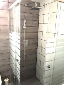 a shower with a glass door in a bathroom at Pegasus Amazing Flat, 15min Walk To The Beach in Chania