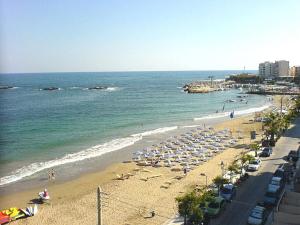 Ein Strand mit einem Haufen Regenschirme und dem Ozean in der Unterkunft Pegasus Amazing Flat, 15min Walk To The Beach in Chania