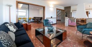 馬塔羅的住宿－Catalunya Casas Seafront bliss for 16 people 40km to Barcelona!，客厅配有蓝色的沙发和玻璃桌