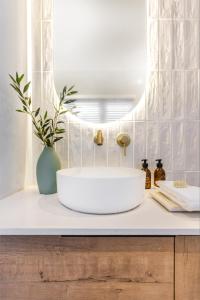 a bathroom with a white sink and a mirror at Feather Nest Guest House in Oudtshoorn