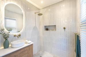 a bathroom with a sink and a mirror at Feather Nest Guest House in Oudtshoorn