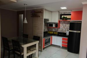 a kitchen with a table and a black refrigerator at Residence Iracema Porto in Fortaleza