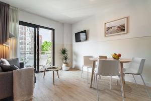 ein Wohnzimmer mit einem Tisch und einem Sofa in der Unterkunft Apartments Sata Olimpic Village Area in Barcelona