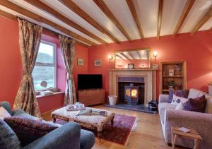 a living room with red walls and a fireplace at Bizzys Place in Gunnerside