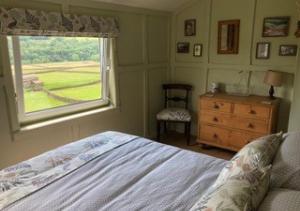 a bedroom with a bed and a window and a dresser at Bizzys Place in Gunnerside