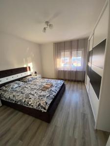 um quarto com uma cama e piso em madeira em Apartman Drina em Berilovac