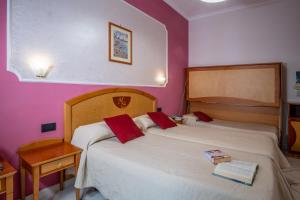 2 Betten in einem Zimmer mit lila Wänden in der Unterkunft Hotel Savoia Sorrento in Sorrent