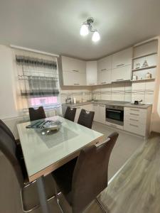 uma cozinha com mesa e cadeiras num quarto em Apartman Drina em Berilovac