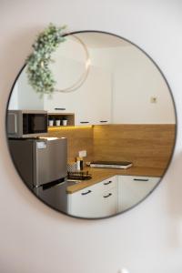 een spiegelbeeld van een keuken met een magnetron bij Apartman Roko in Vrata