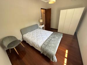 1 dormitorio con 1 cama y 1 silla en Casa da Poça - Guest House en Braga