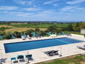 a swimming pool with lounge chairs and a view at Domaine de l'Envolée in Tourbes