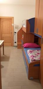 Habitación con cama, mesa y puerta en Casa Sonia en Auronzo di Cadore