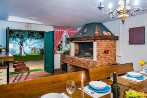 Una sala de estar con una chimenea de ladrillo y una mesa con una vela. en Villa Niente da Fare, en Šibenik