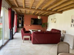 ein Wohnzimmer mit einem roten Sofa und einem TV in der Unterkunft Gite de la bergerie du gatinais *** 