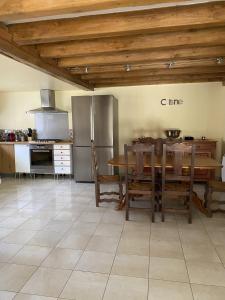 eine Küche mit einem Tisch und eine Küche mit einem Kühlschrank in der Unterkunft Gite de la bergerie du gatinais *** 