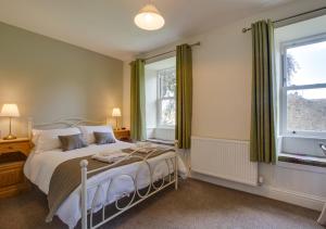 1 dormitorio con cama y ventana grande en Beech House, en Hawes