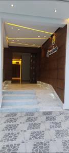 a lobby with stairs and a sign on a wall at Appartement à la plage Mehdia pour famille uniquement in Kenitra