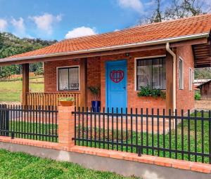 波梅罗迪Chale Greifswald Pomerode的一座带蓝色门和栅栏的房子